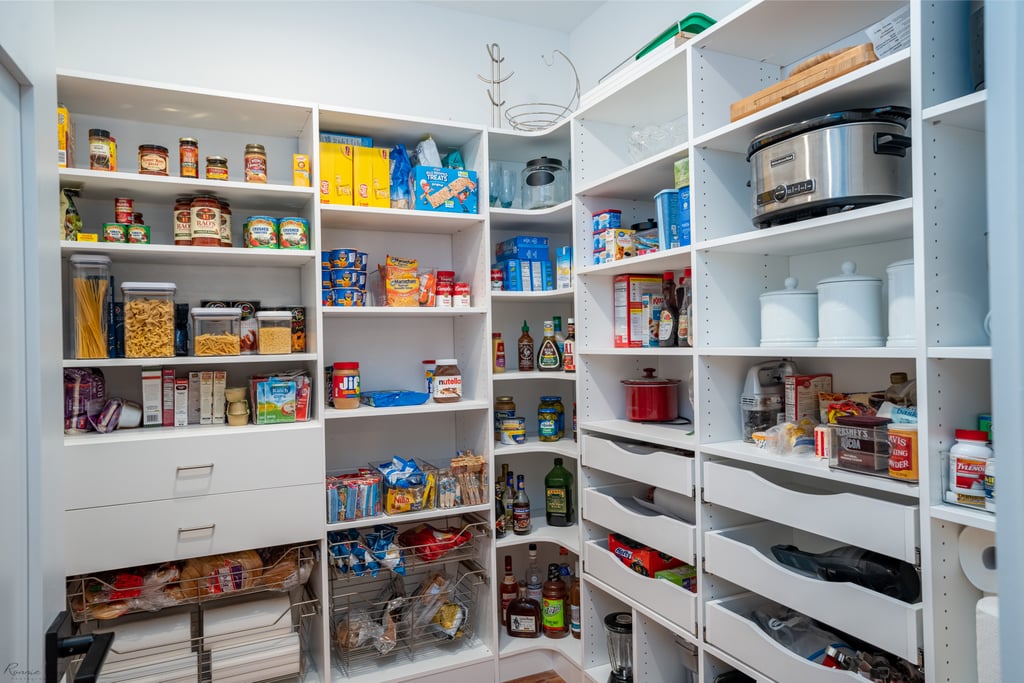 Custom walk-in pantry with deep shelves, pull-out baskets, and appliance storage