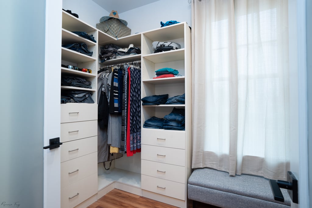 Custom reach-in closet with folded-clothing shelves and drawer banks